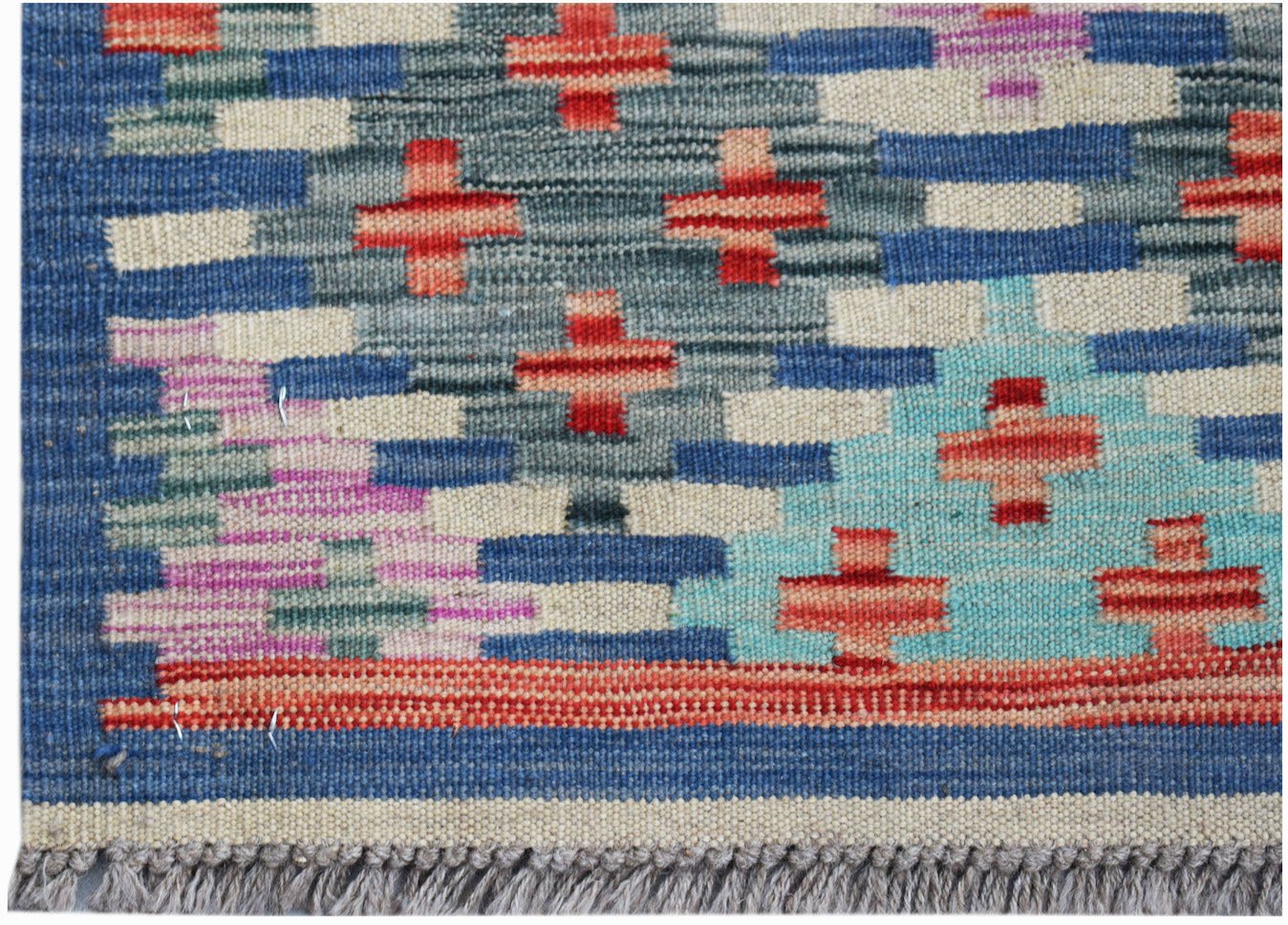 Handwoven Afghan Maimana kilim rug featuring a geometric pattern in blue, red, and cream tones.