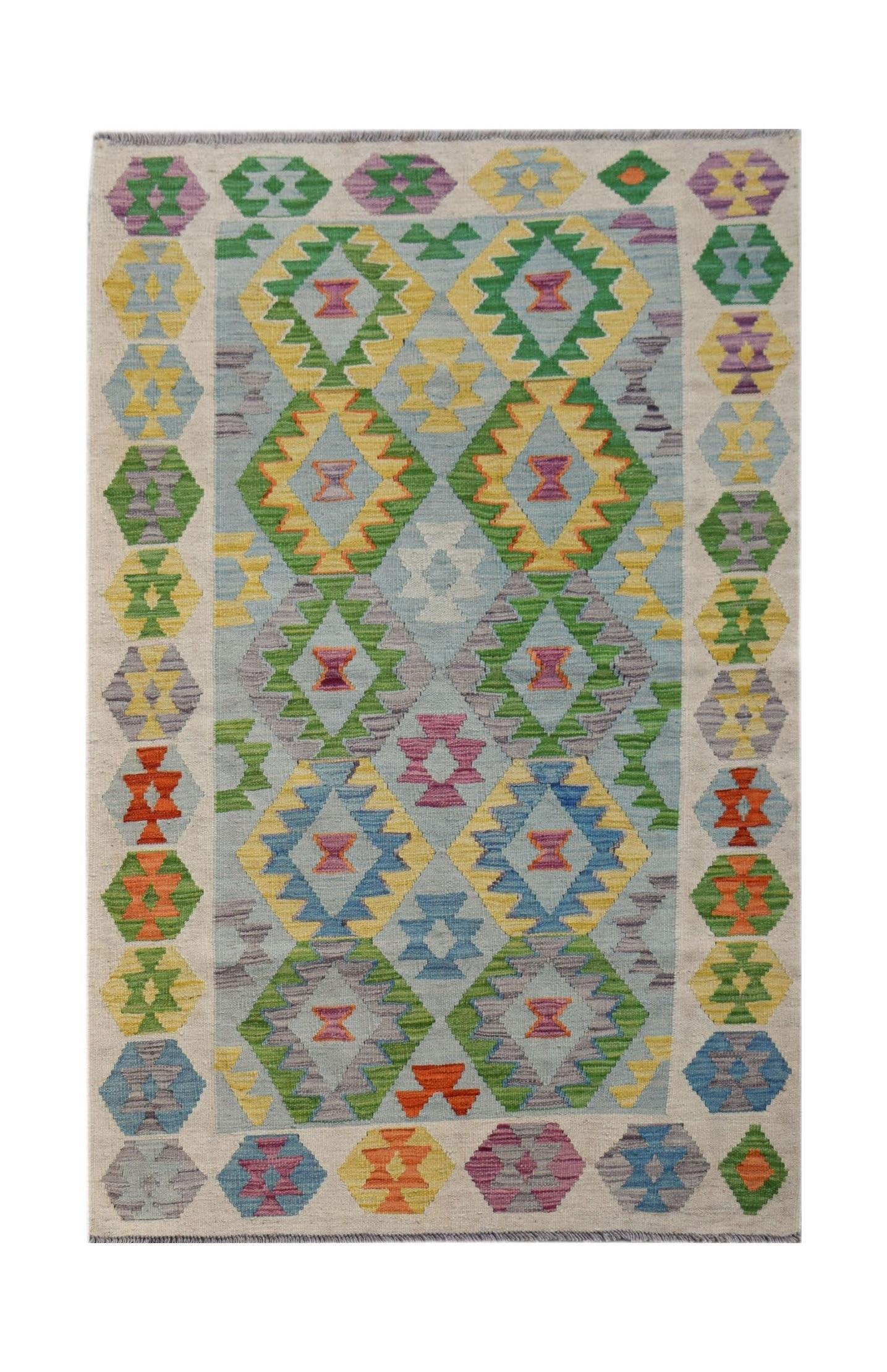 Handwoven Afghan Maimana kilim rug featuring a colorful geometric diamond pattern on a light base.