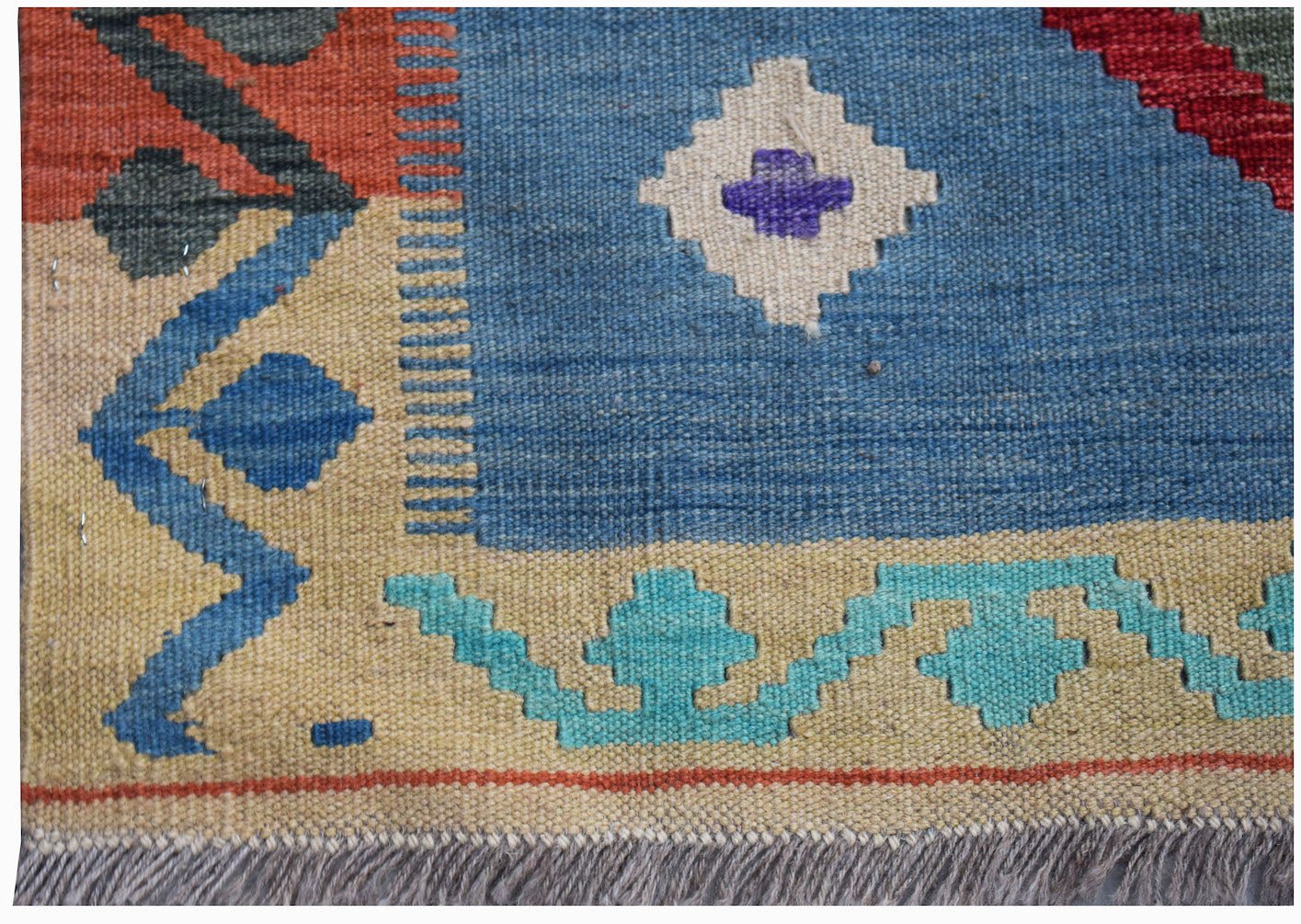 Handwoven Afghan Maimana kilim featuring geometric patterns in blue, cream, and vibrant accents.