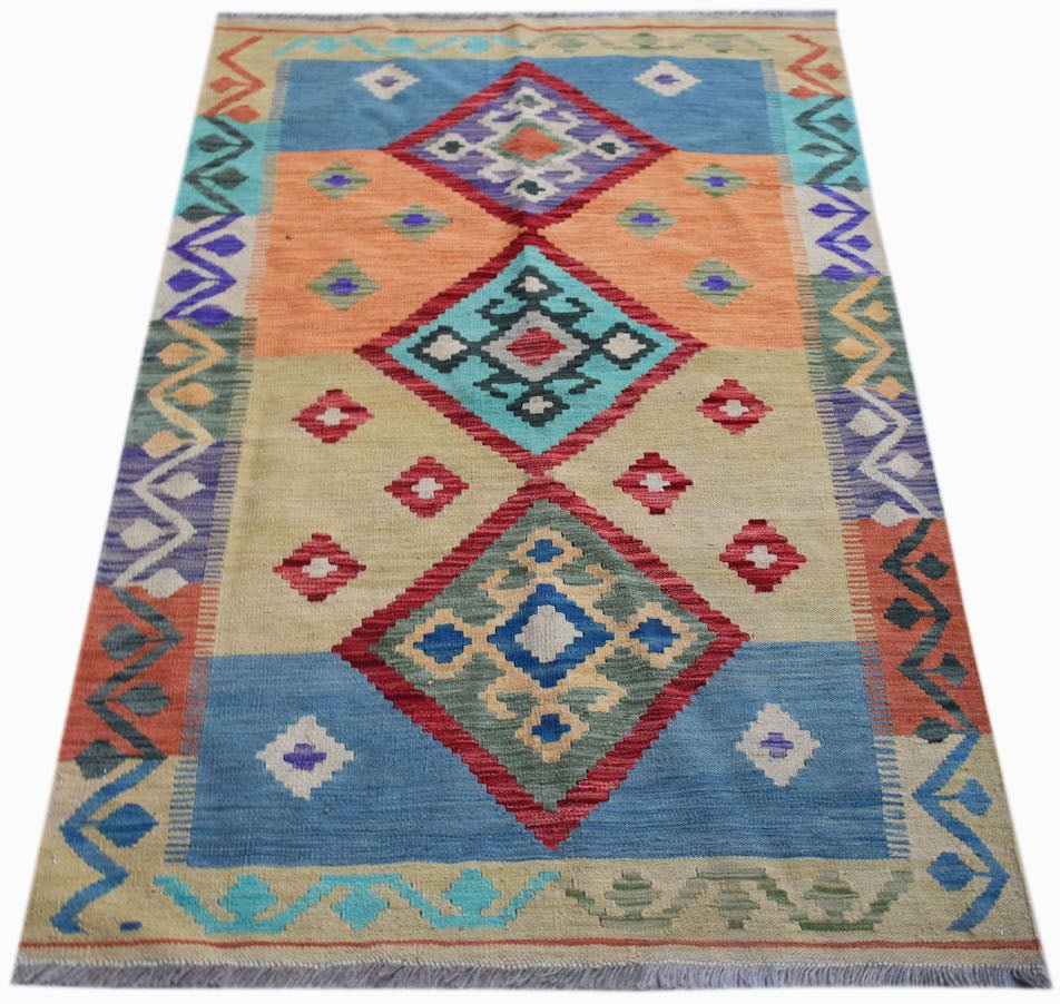 Handwoven Afghan Maimana kilim rug featuring a colorful geometric diamond pattern on wool.