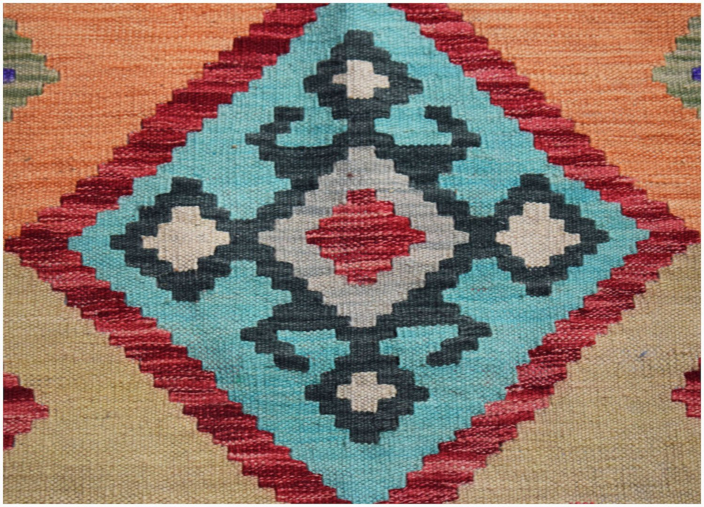 Handwoven Afghan Maimana kilim featuring a geometric diamond pattern in vibrant wool colors.