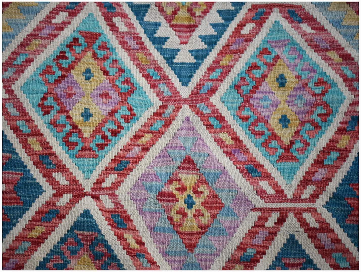 Handwoven Afghan Maimana kilim featuring a vibrant geometric diamond pattern in wool.