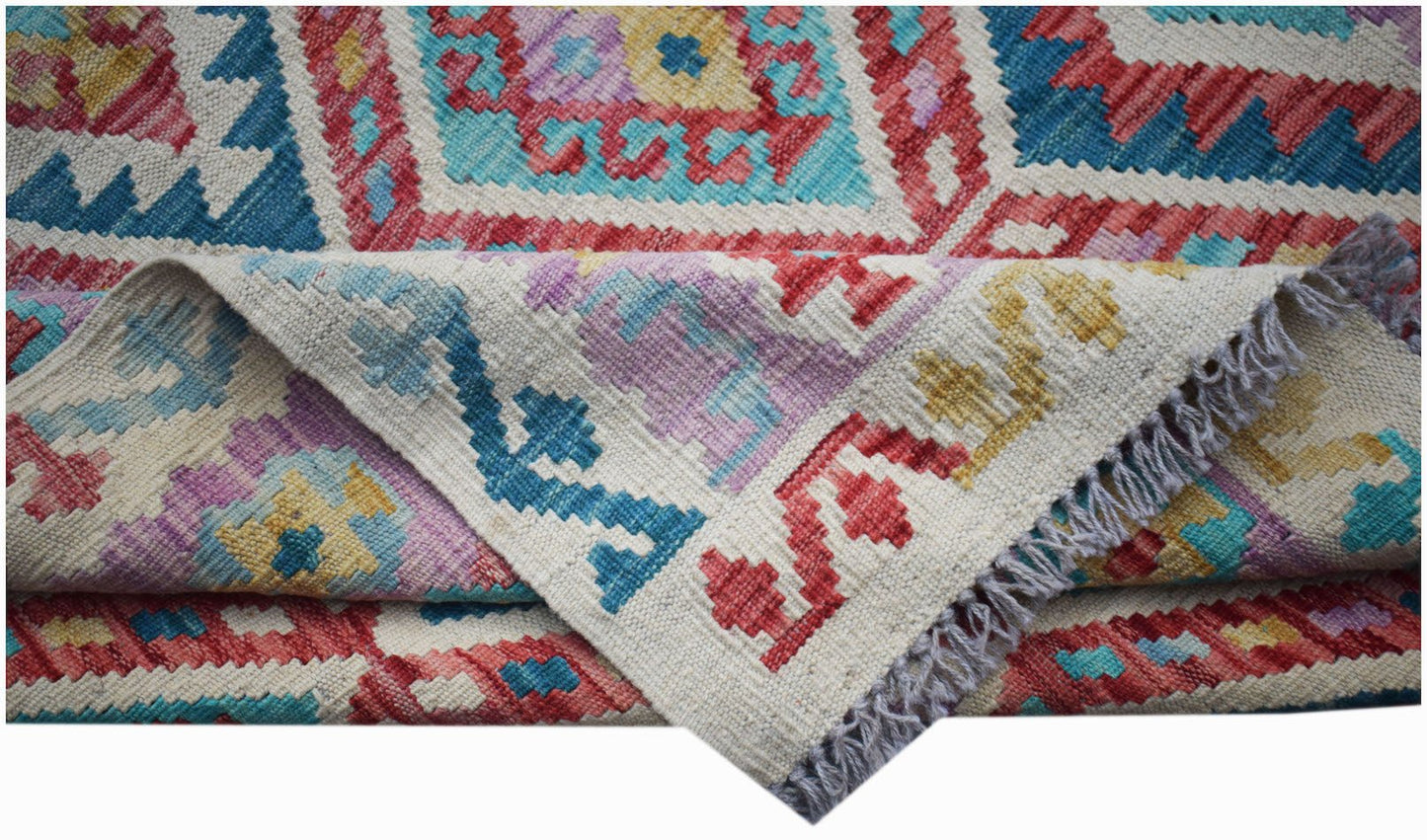 A handmade Afghan Maimana kilim rug featuring a colorful geometric pattern and flatweave texture.