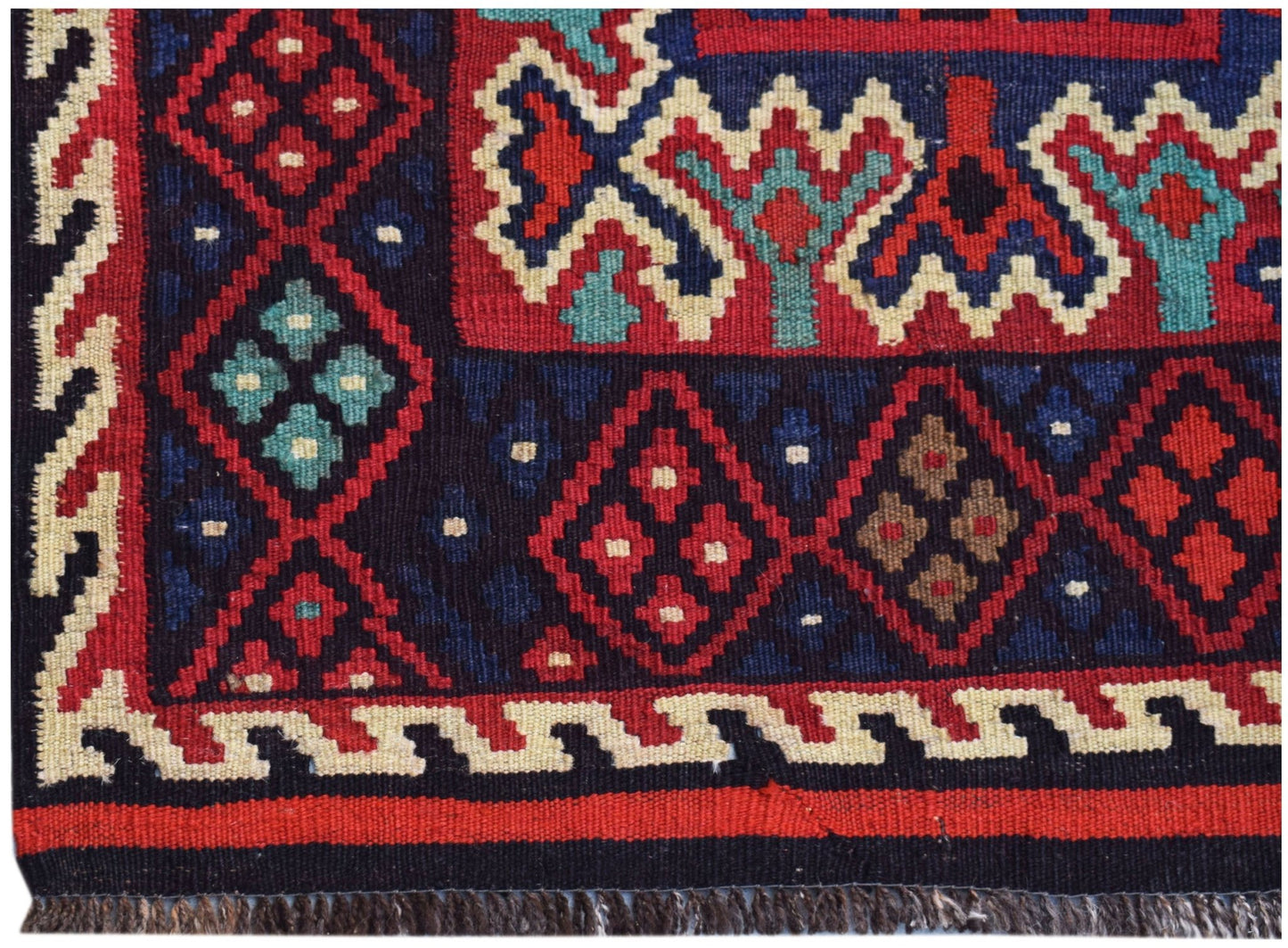 Handwoven Afghan Maimana kilim featuring a geometric pattern in red, blue, and cream wool.
