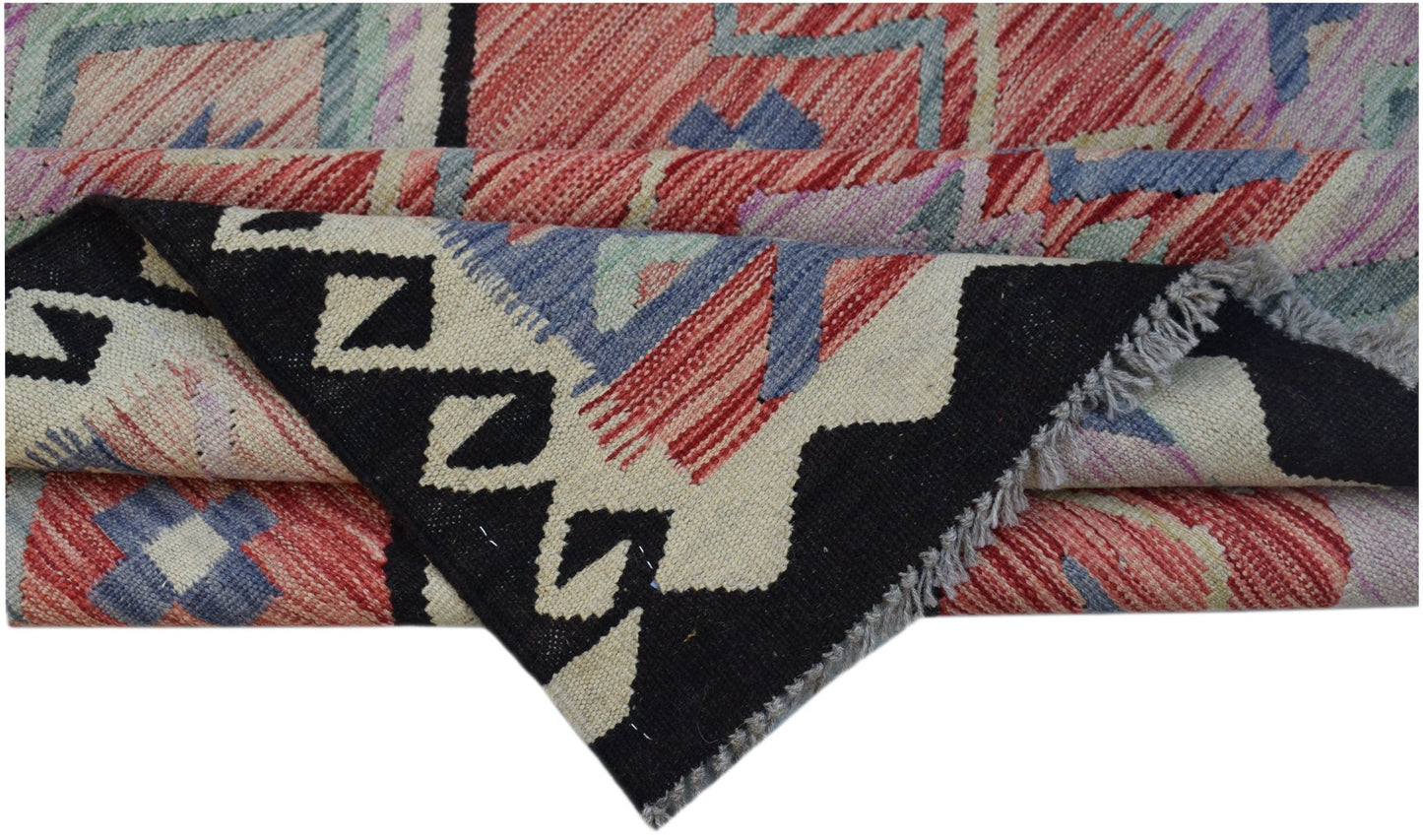 A handwoven Afghan Maimana kilim rug featuring a geometric pattern in red, blue, and black.