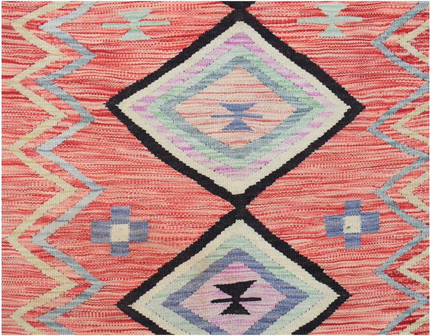 Handwoven Afghan Maimana kilim featuring a red background with geometric diamond and cross patterns.