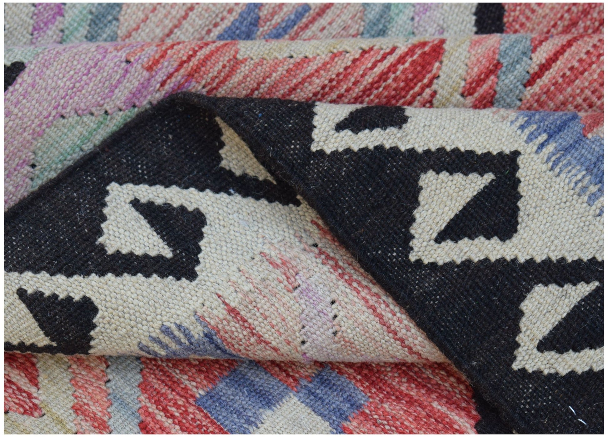 A handwoven Afghan Maimana kilim featuring a geometric pattern in black, red, and blue wool.