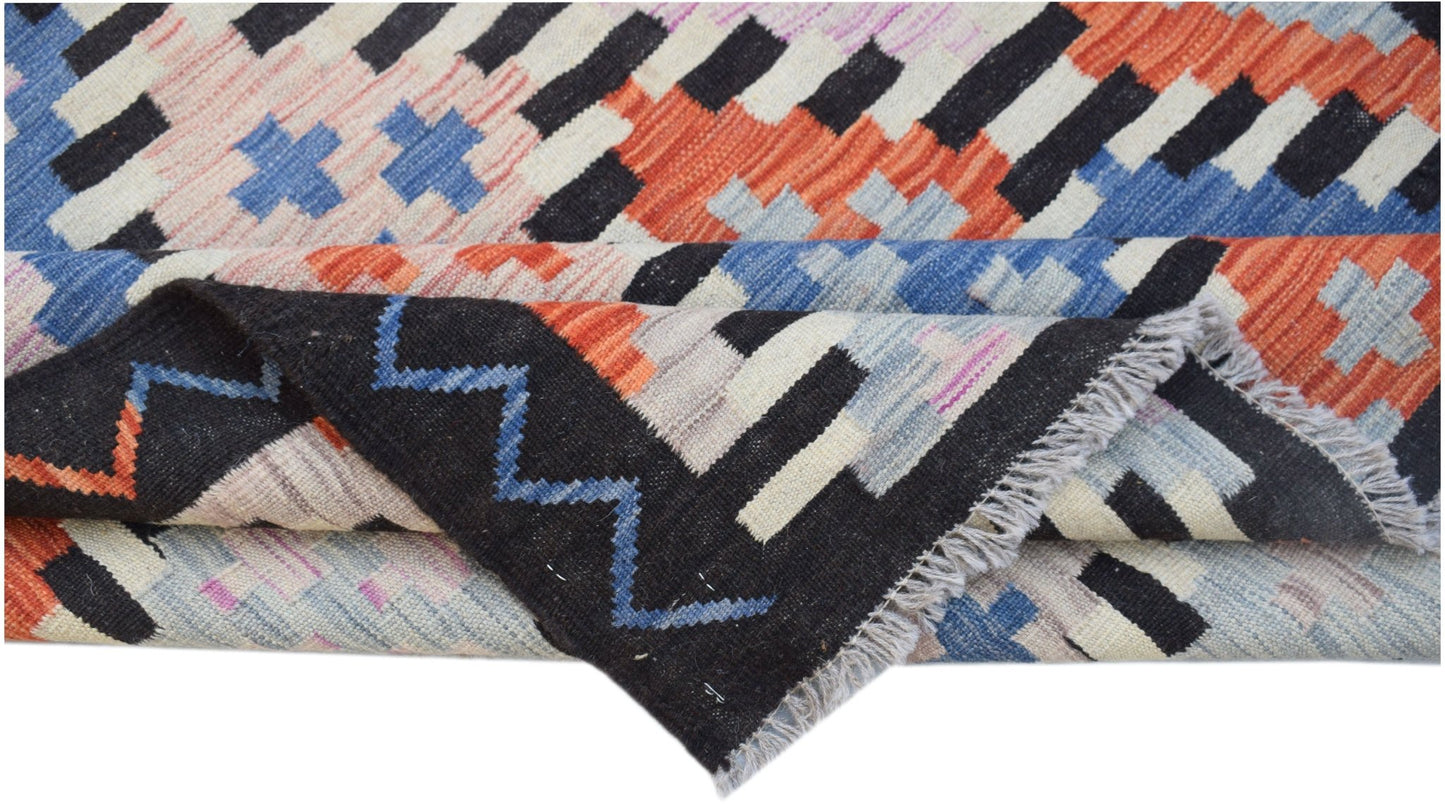 A handmade Afghan Maimana kilim rug featuring a geometric pattern in vibrant multicolored wool.