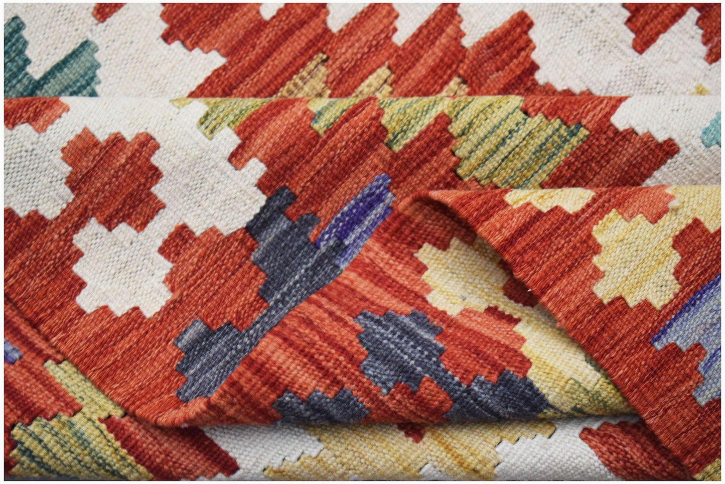 Handwoven Afghan Maimana kilim rug featuring a geometric pattern in red, yellow, and blue tones.