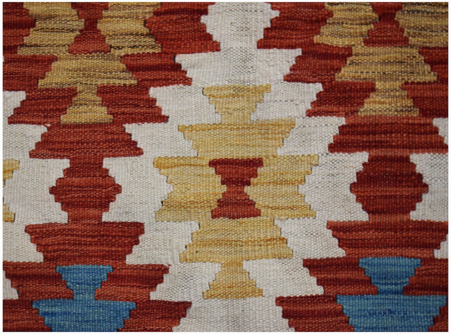 Handwoven Afghan Maimana kilim featuring a geometric pattern in red, yellow, blue, and white.