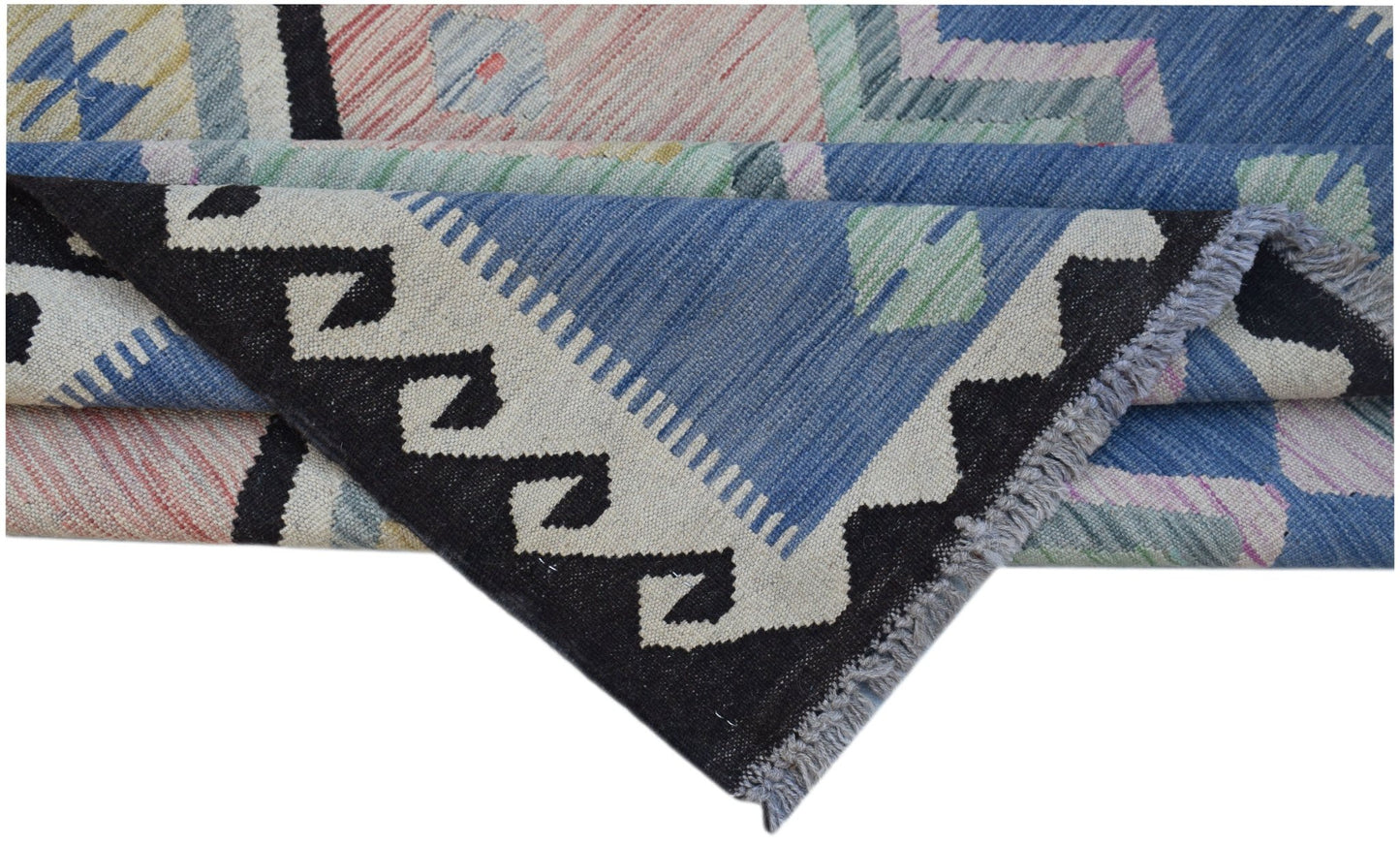 A handwoven Afghan Maimana kilim rug featuring a geometric pattern in blue, black, and cream.