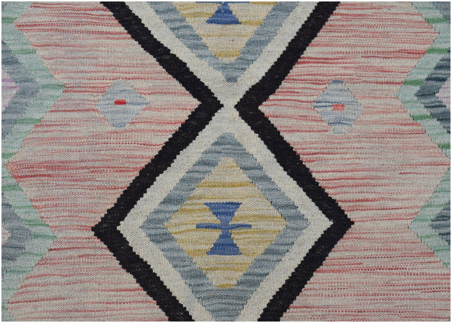 Handwoven Afghan Maimana kilim featuring a geometric diamond pattern in pink, blue, and yellow.