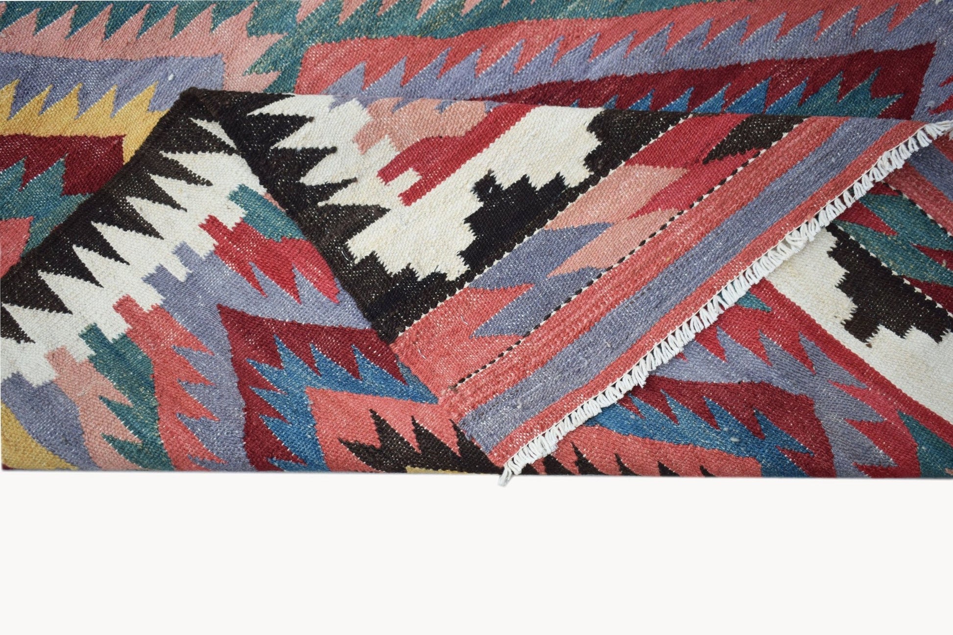 A handmade Afghan Maimana kilim rug featuring a geometric pattern in red, blue, and yellow wool.