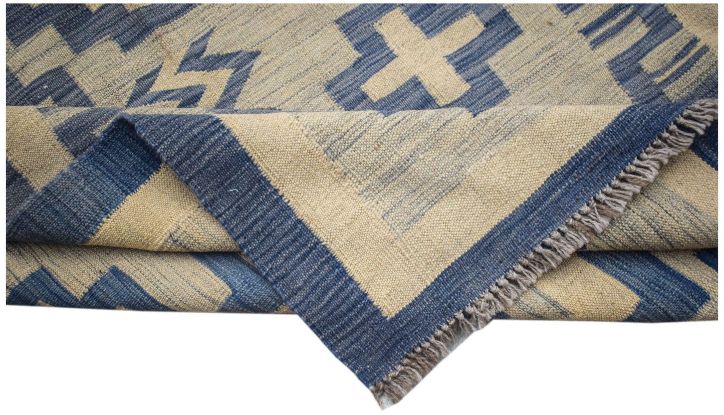 A handmade Afghan Maimana kilim rug featuring a blue and beige geometric pattern with fringe.