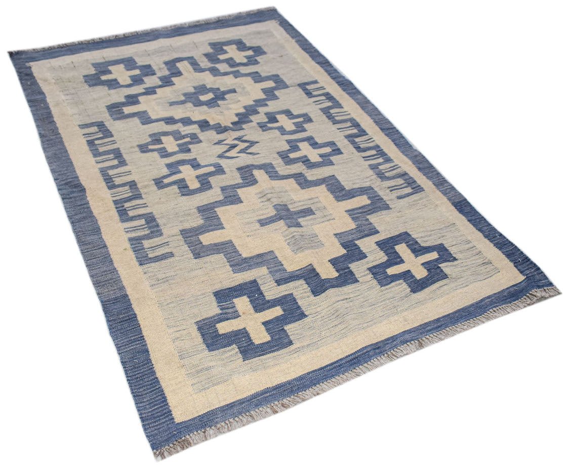 A rectangular Afghan Maimana kilim featuring blue geometric cross patterns on a cream background.