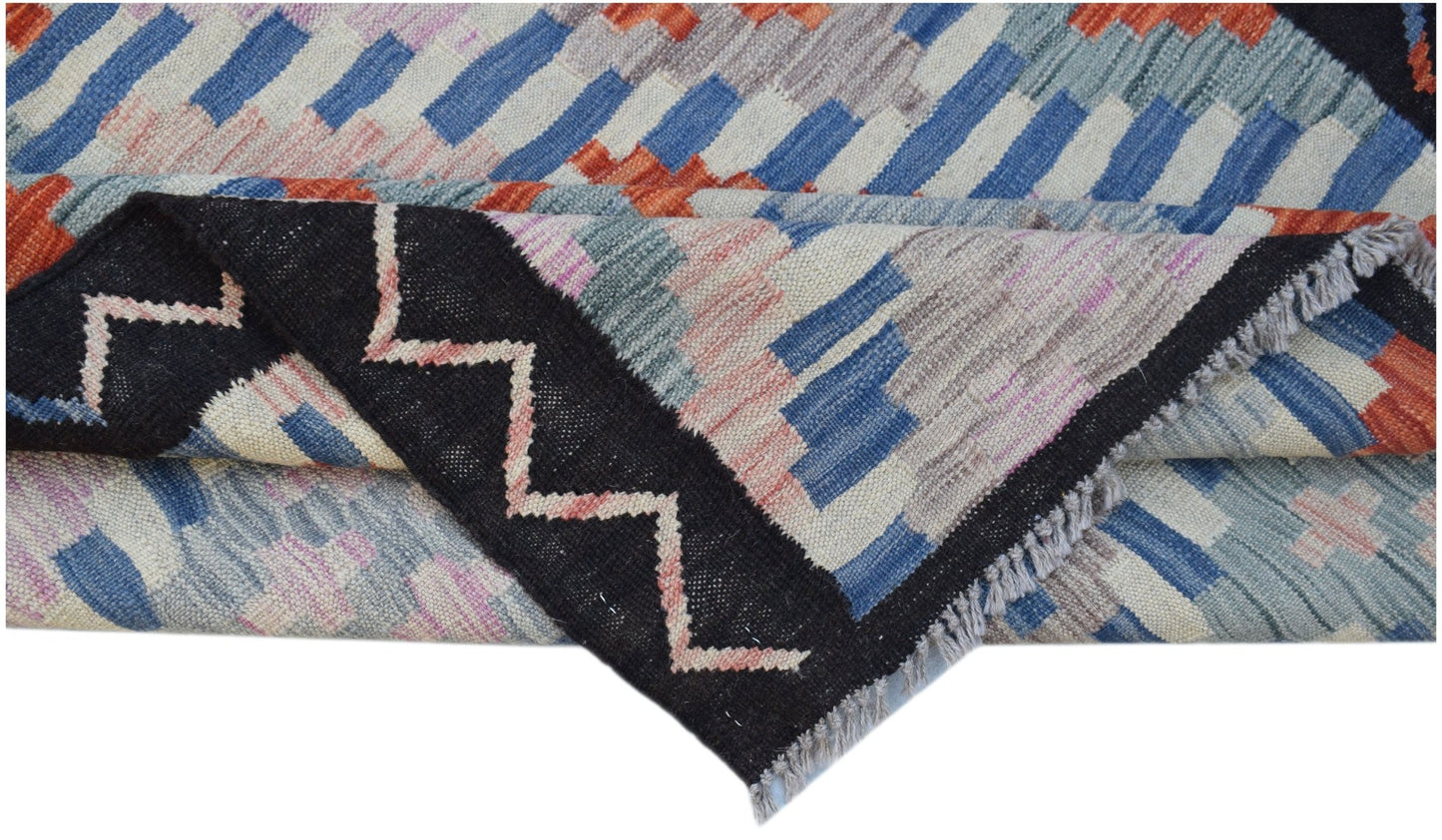A handmade Afghan Maimana kilim featuring a geometric pattern in blue, orange, and pink wool.
