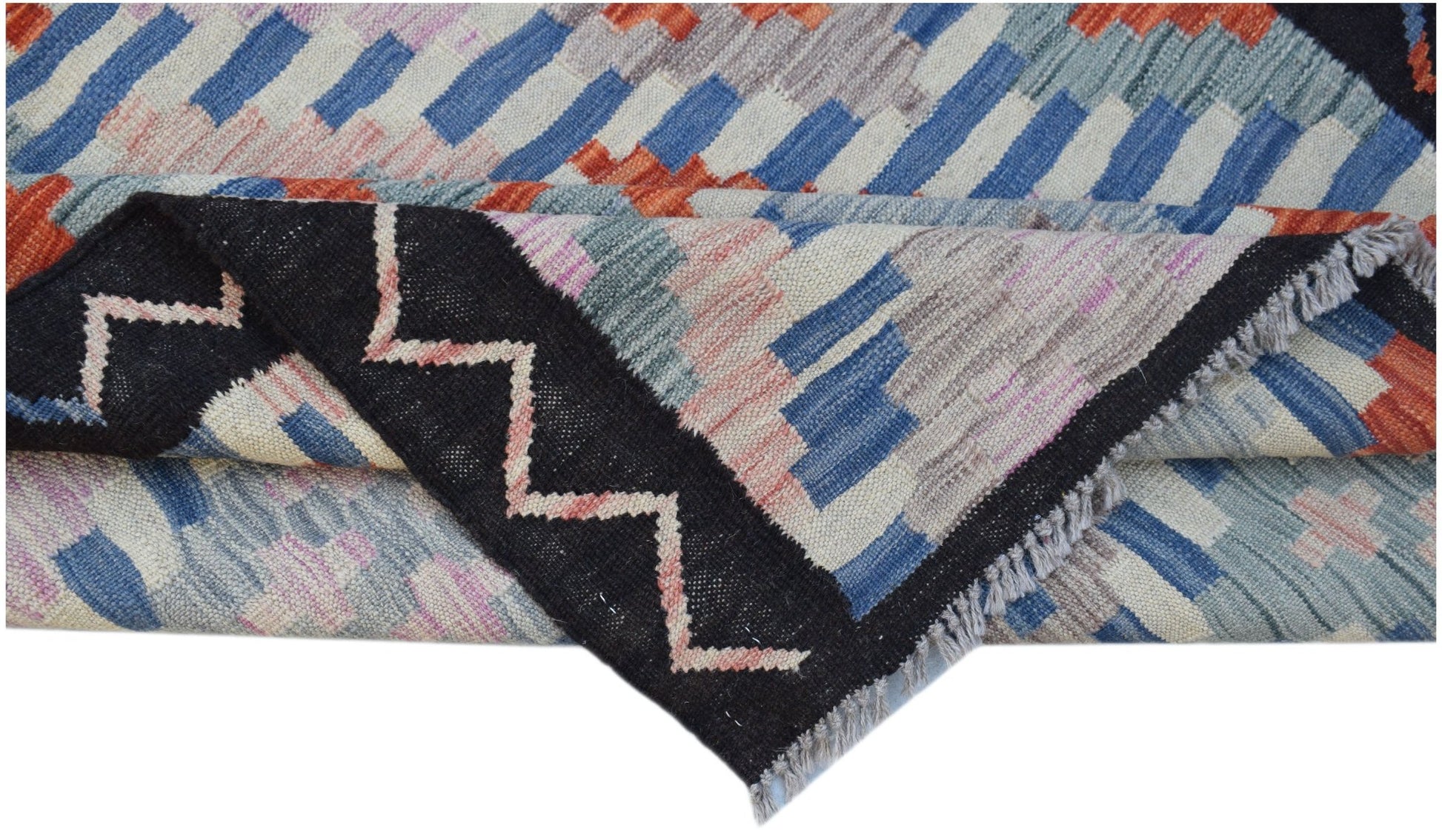A handmade Afghan Maimana kilim featuring a geometric pattern in blue, orange, and pink wool.