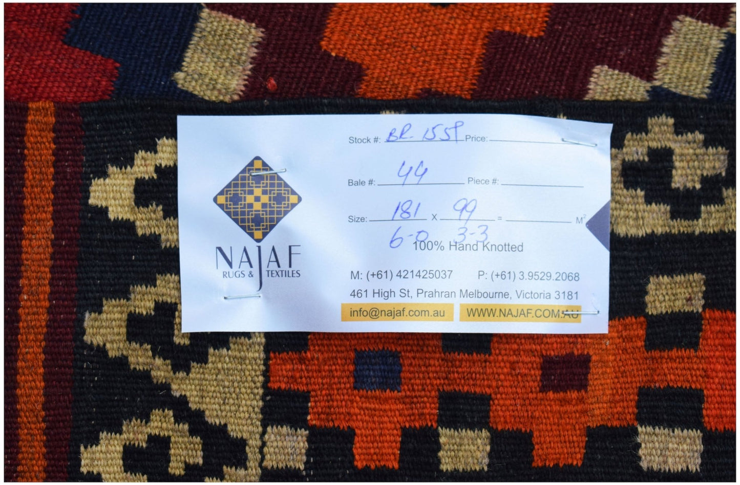 A handmade Afghan Maimana kilim featuring a geometric pattern in red, orange, and dark blue.