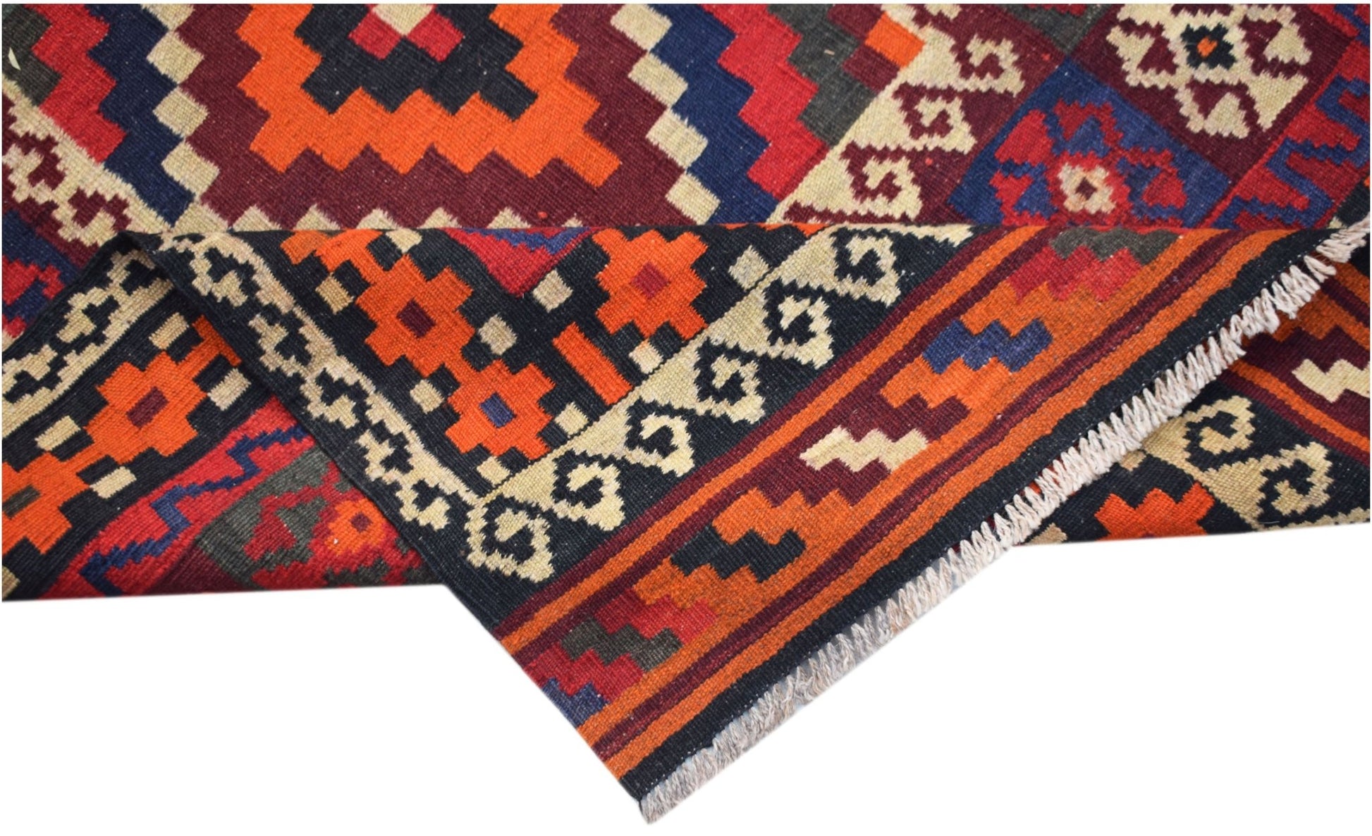 A handmade Afghan Maimana kilim rug featuring vibrant geometric patterns in wool.