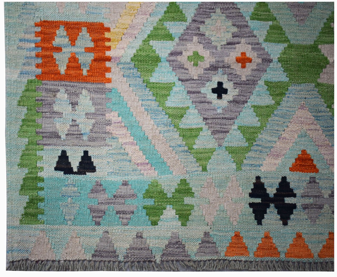 Handwoven Afghan Maimana kilim rug featuring a geometric pattern in vibrant wool colors.