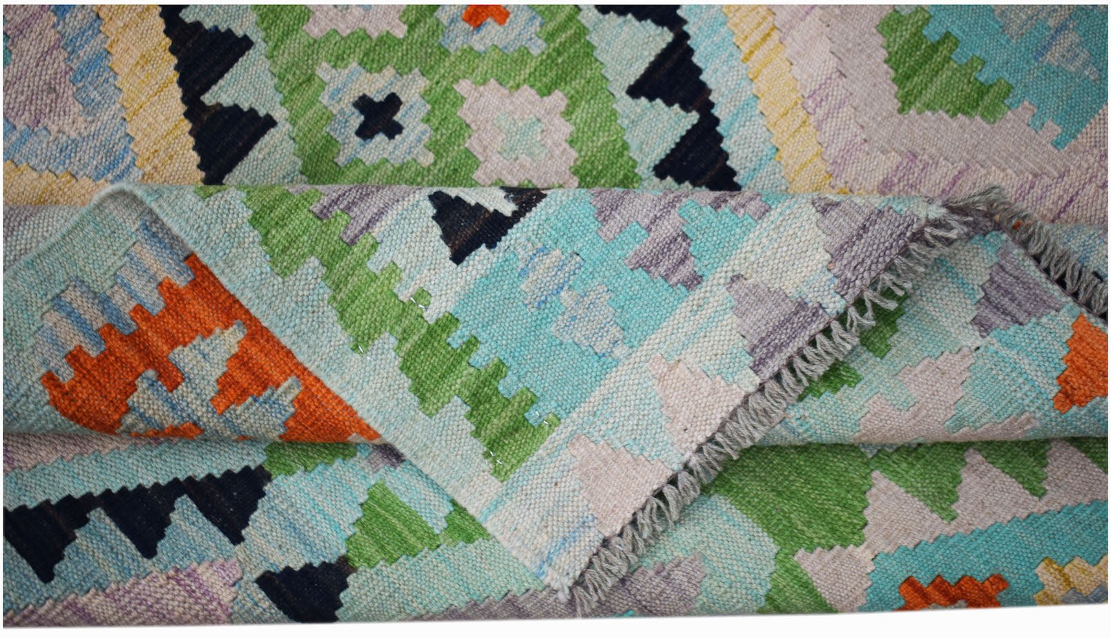 A handwoven Afghan Maimana kilim rug featuring a colorful geometric pattern and flatweave texture.