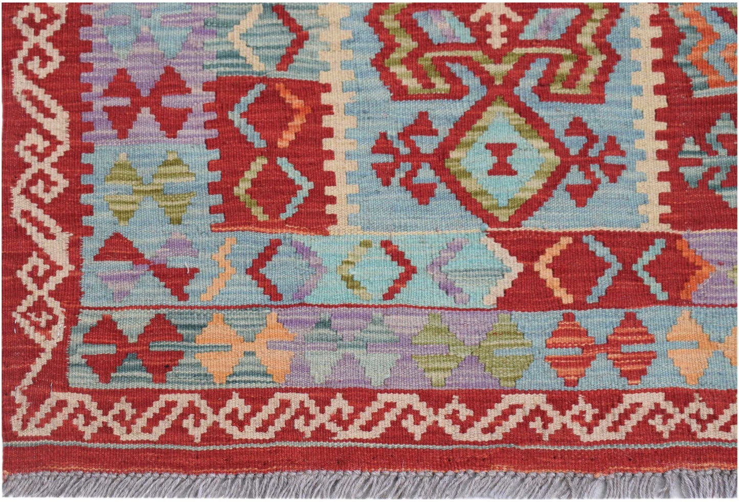 Handwoven Afghan Maimana kilim rug featuring geometric patterns in red, blue, and multicolor wool.