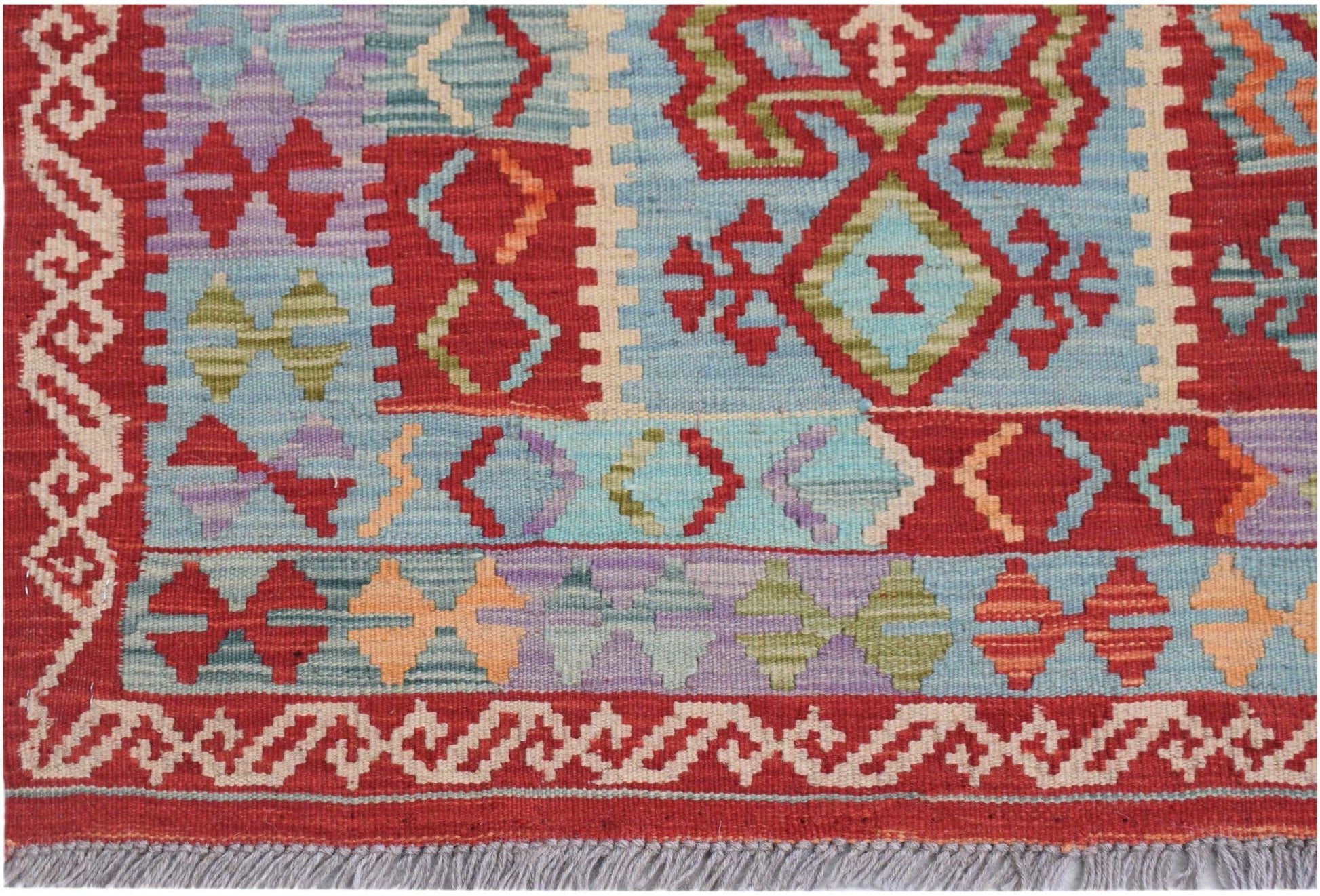 Handwoven Afghan Maimana kilim rug featuring geometric patterns in red, blue, and multicolor wool.