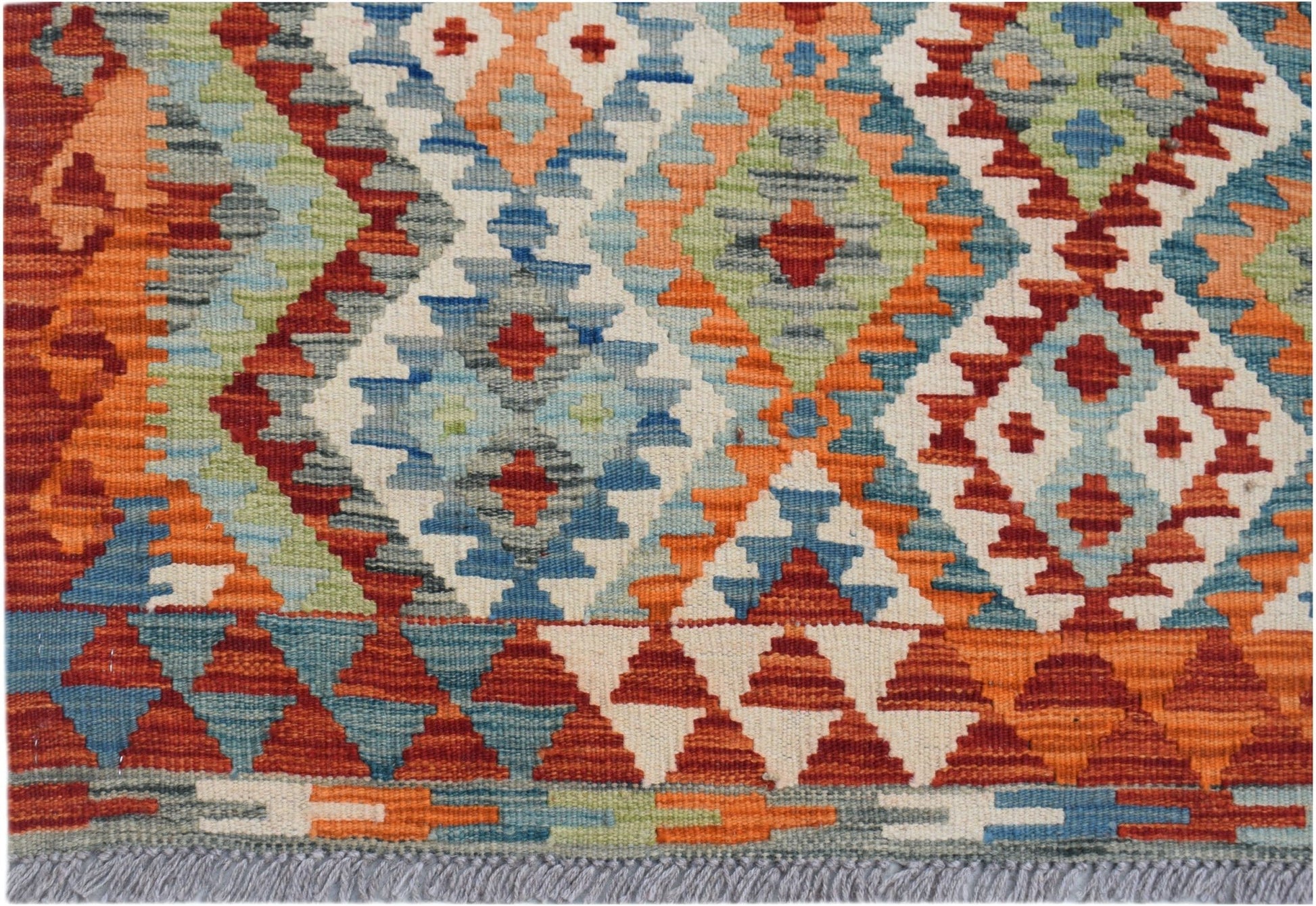 Handwoven Afghan Maimana kilim rug featuring a geometric diamond pattern in vibrant wool colors.