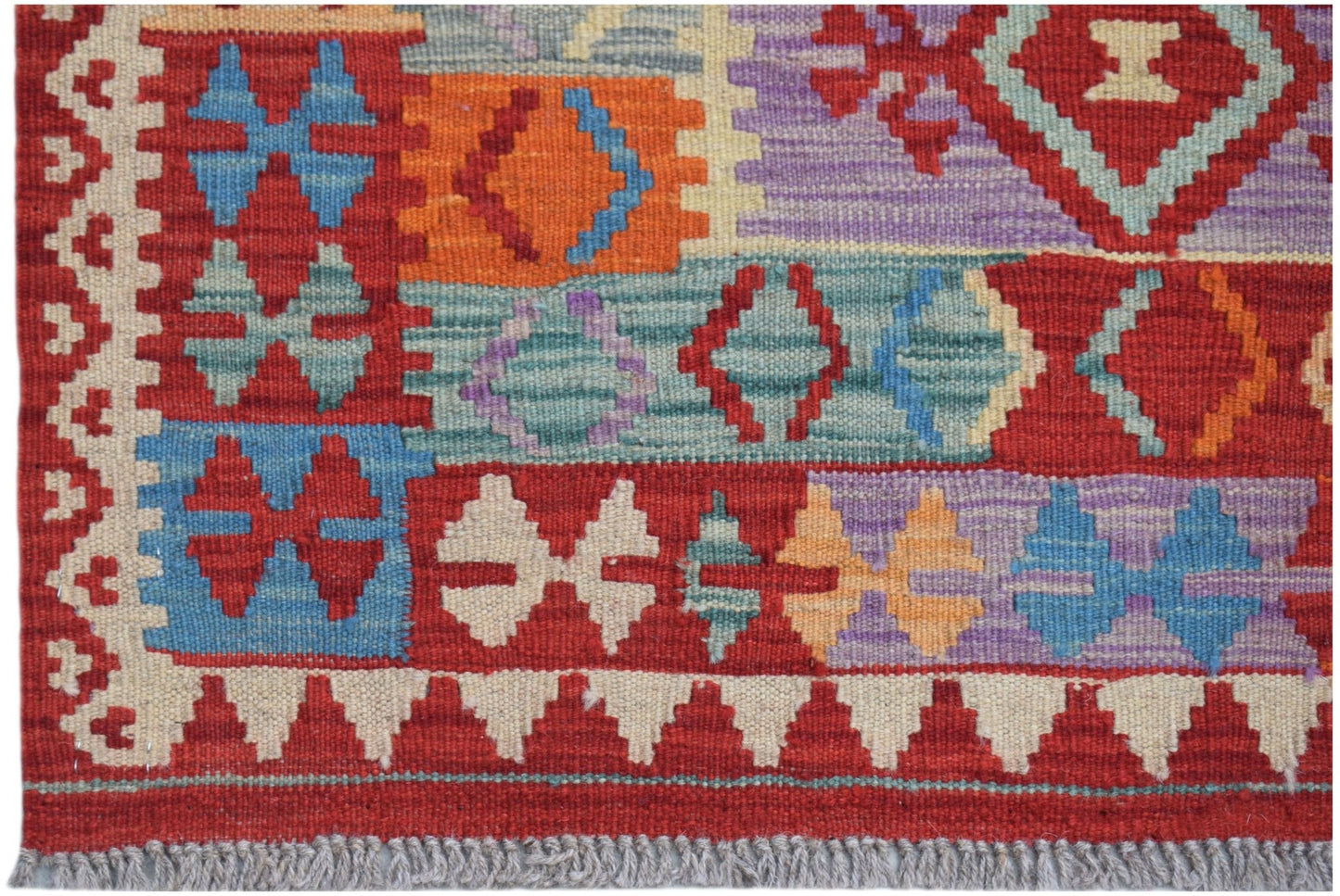 Handwoven Afghan Maimana kilim rug featuring a vibrant geometric pattern in wool.