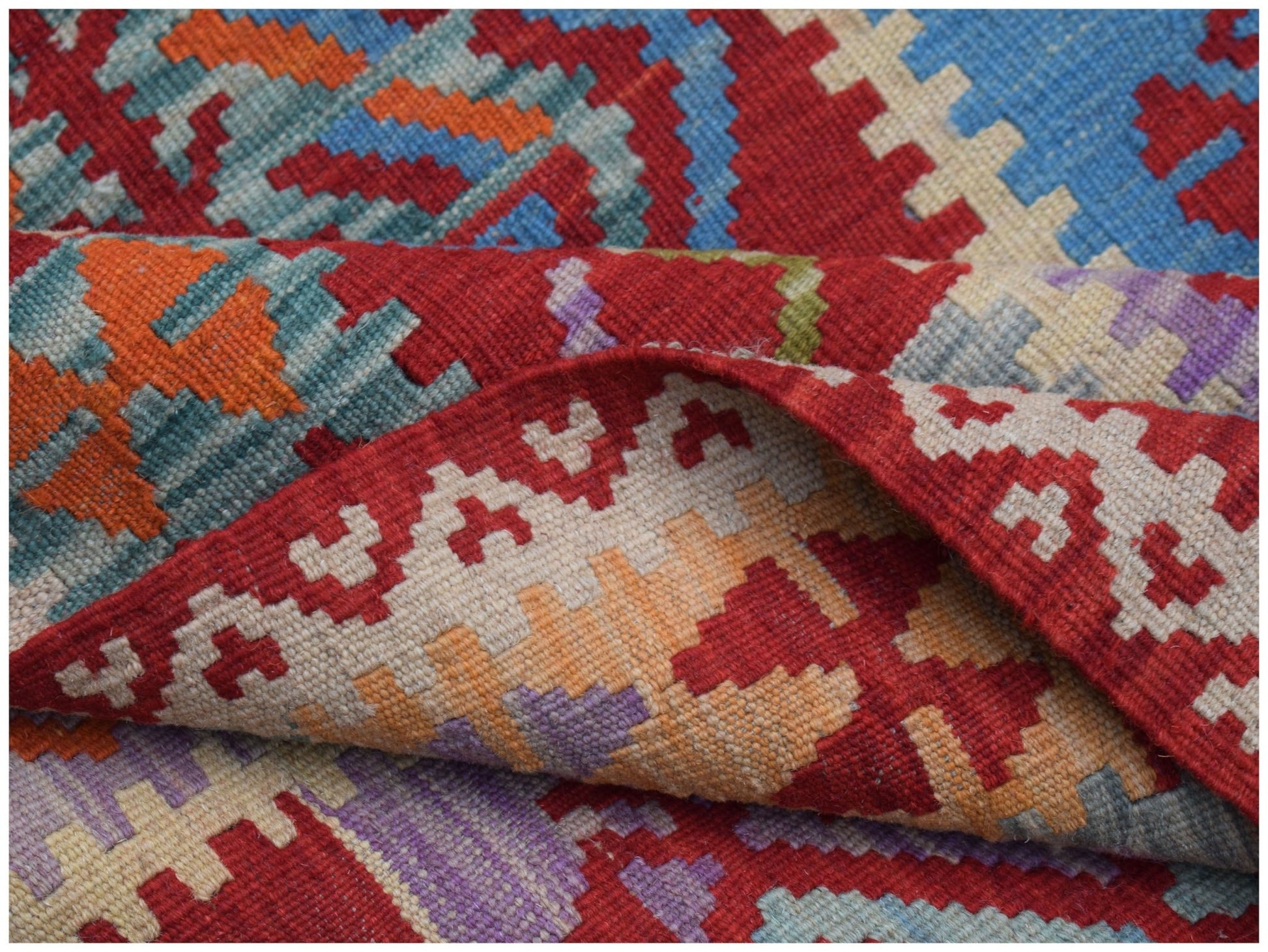 A handmade Afghan Maimana kilim rug featuring a vibrant geometric pattern in wool.