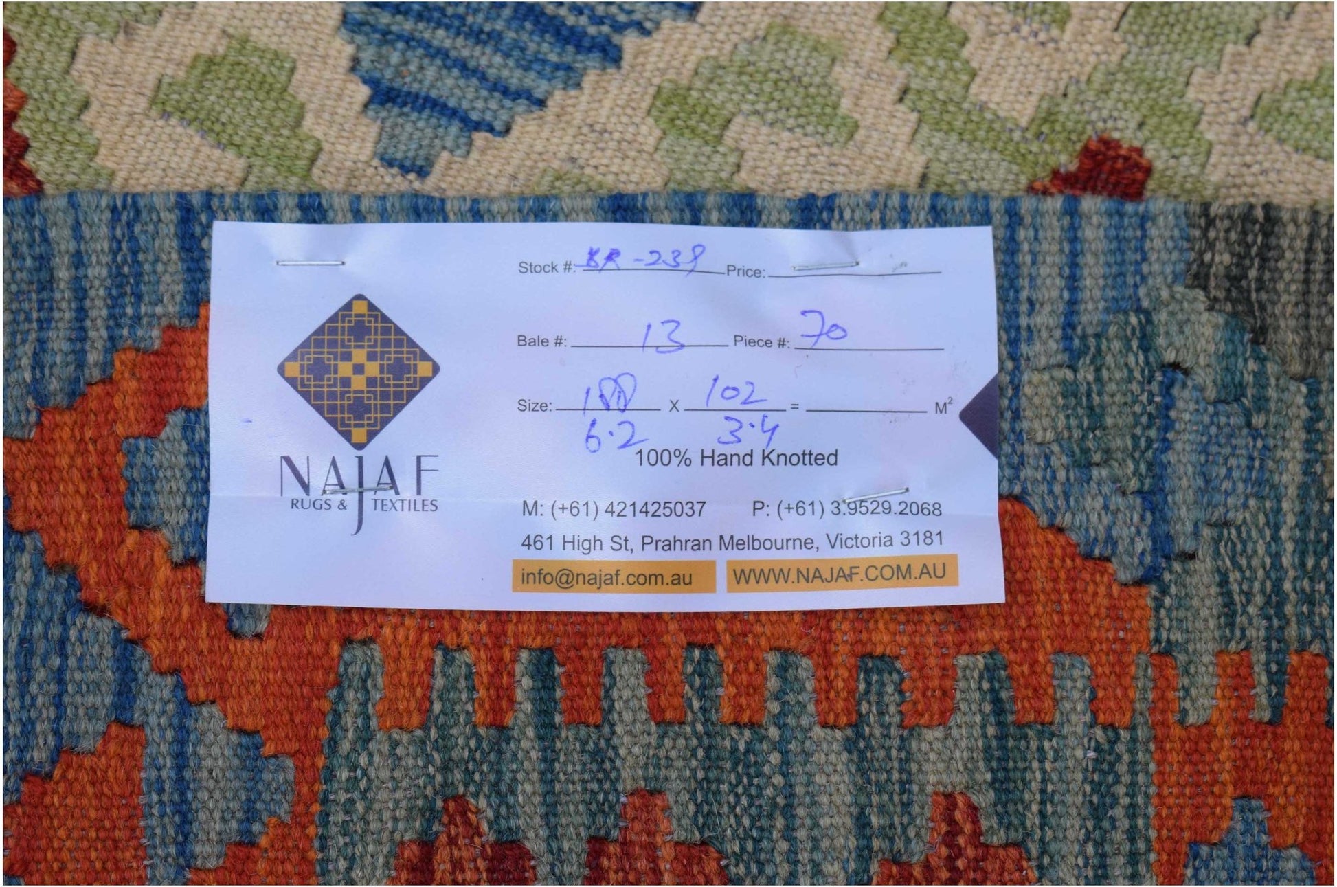 A handwoven Afghan Maimana kilim featuring a geometric pattern in blue, orange, and green tones.