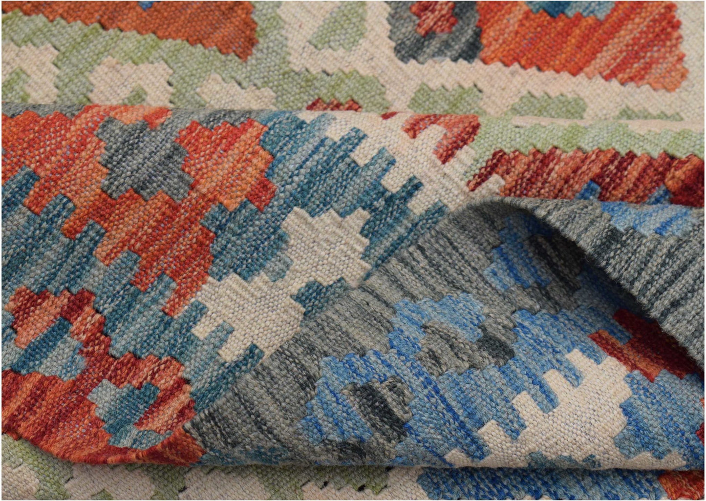 A handwoven Afghan Maimana kilim rug featuring a geometric pattern in blue, orange, and green.