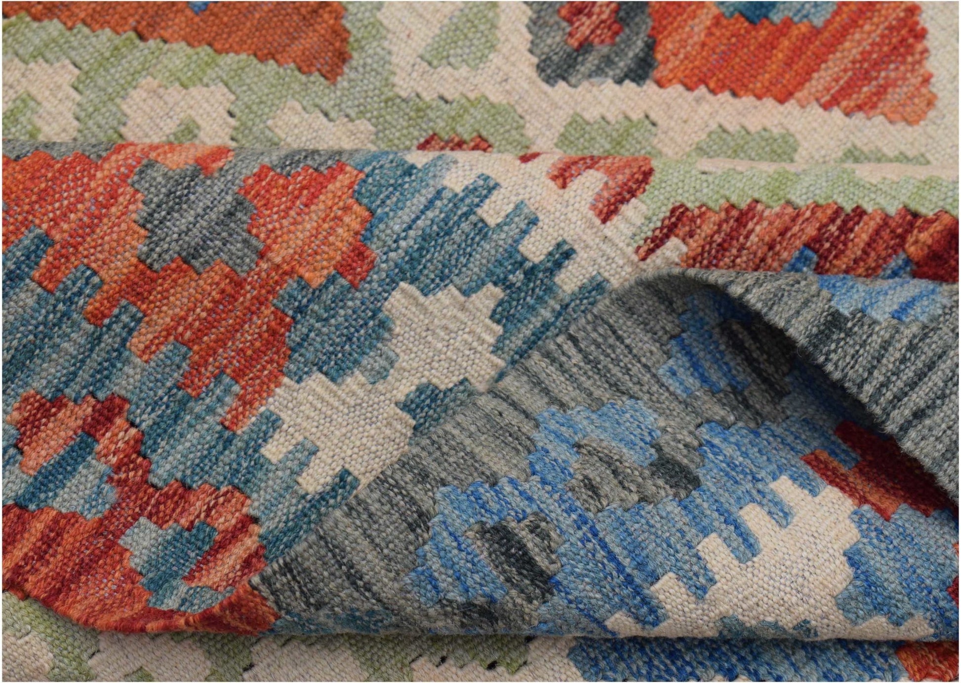 A handwoven Afghan Maimana kilim rug featuring a geometric pattern in blue, orange, and green.