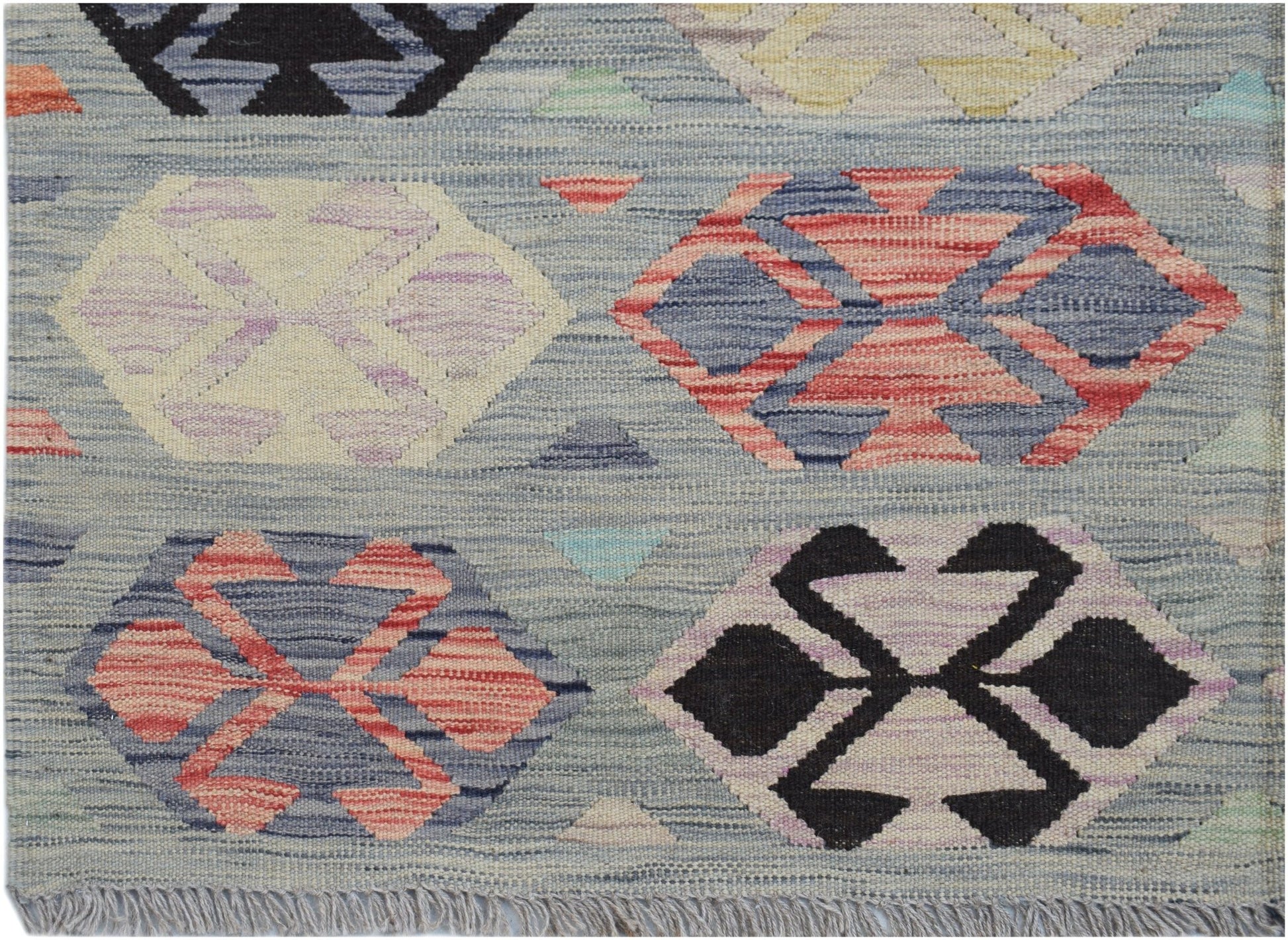 Handwoven Afghan Maimana kilim rug featuring a light blue background with geometric hexagon motifs.