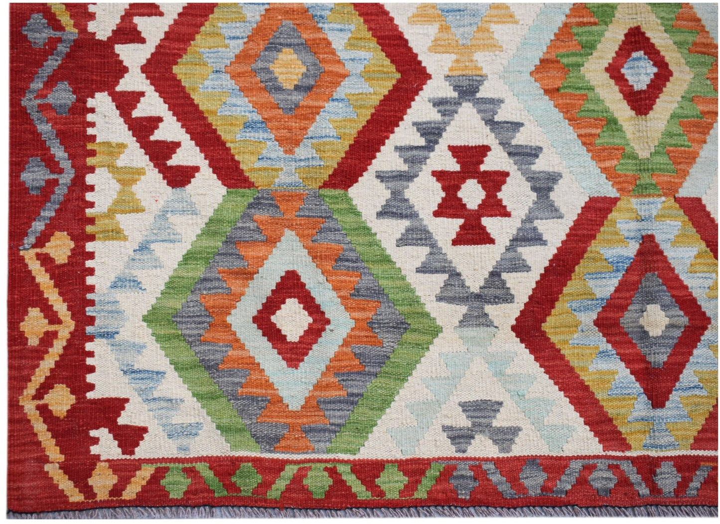 Handwoven Afghan Maimana kilim rug featuring a vibrant geometric diamond pattern in wool.