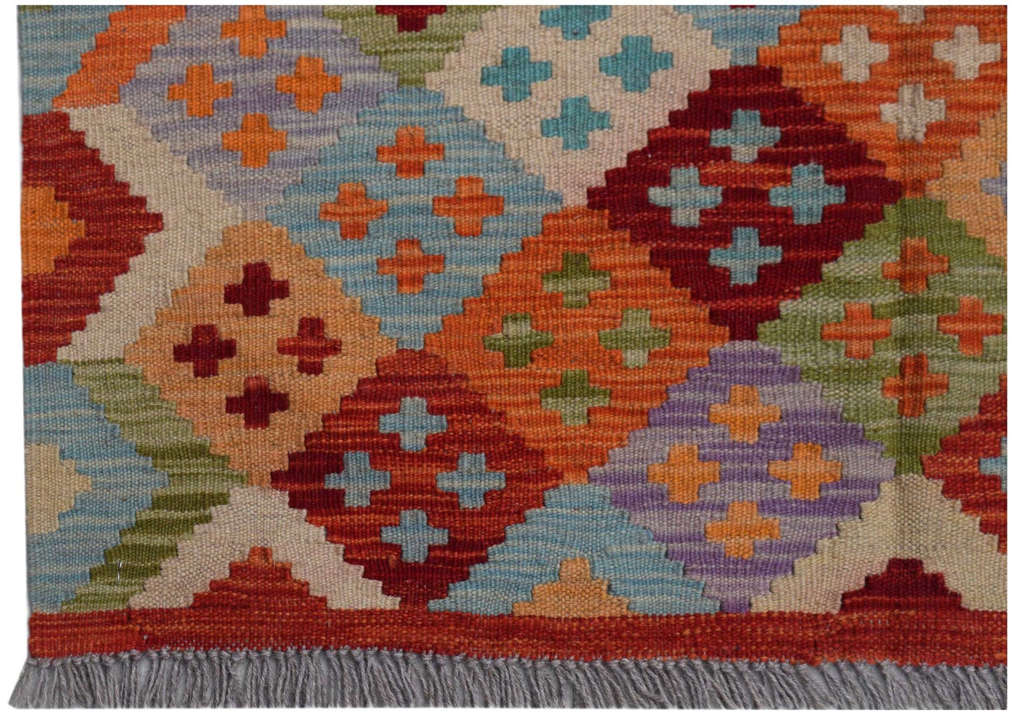 Handwoven Afghan Maimana kilim featuring a colorful geometric diamond pattern and fringe edges.