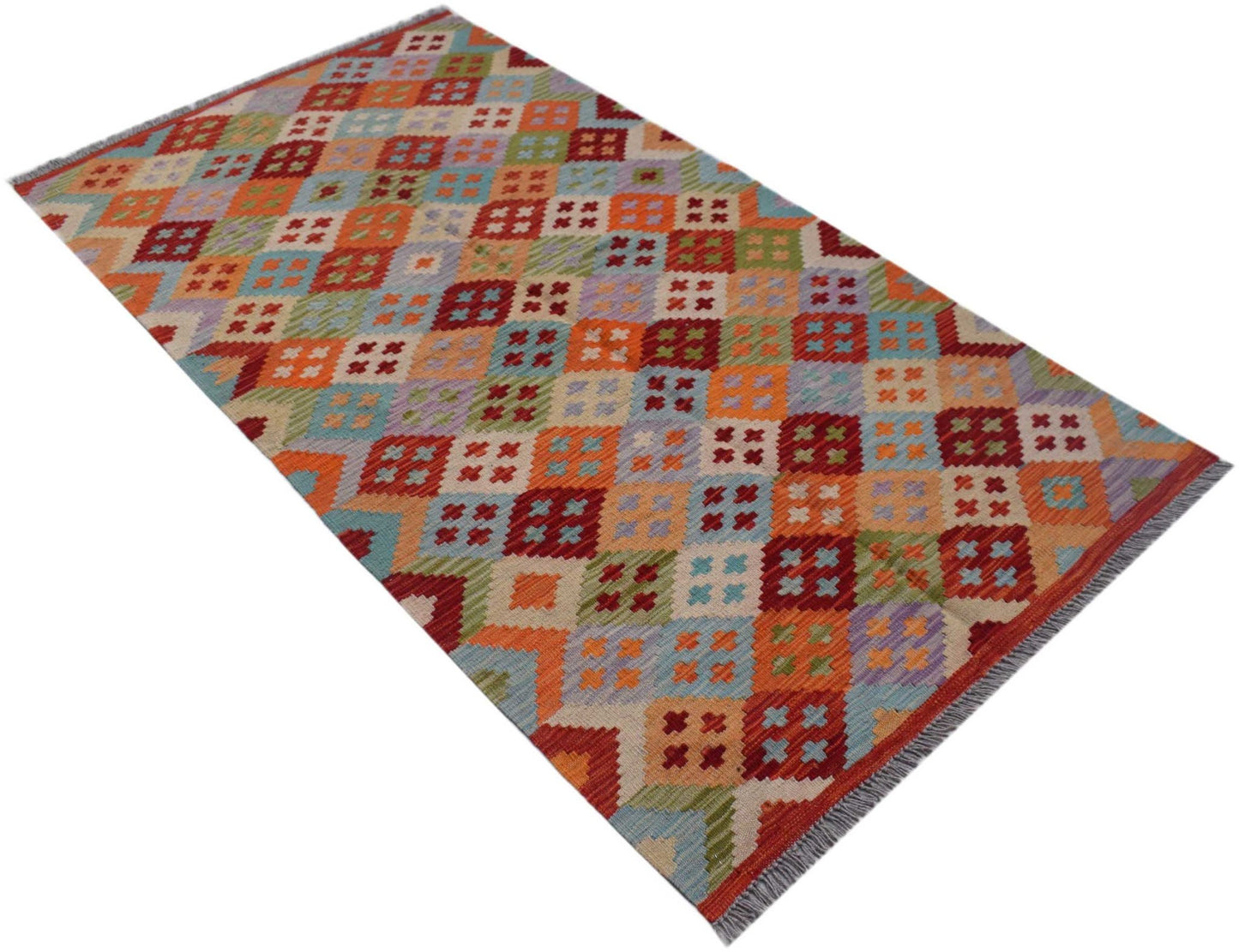 A rectangular Afghan Maimana kilim rug featuring a colorful geometric pattern of small crosses.