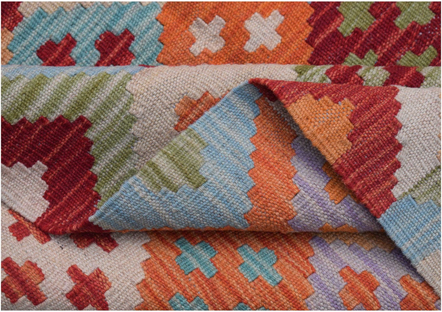 A handwoven Afghan Maimana kilim rug featuring a vibrant geometric pattern in wool.