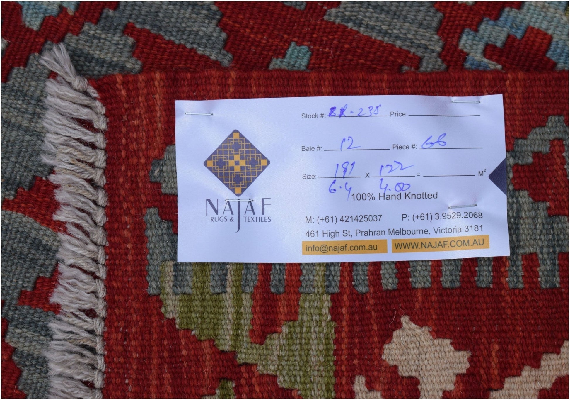 A handwoven Afghan Maimana kilim featuring a geometric pattern in red, blue, and beige tones.