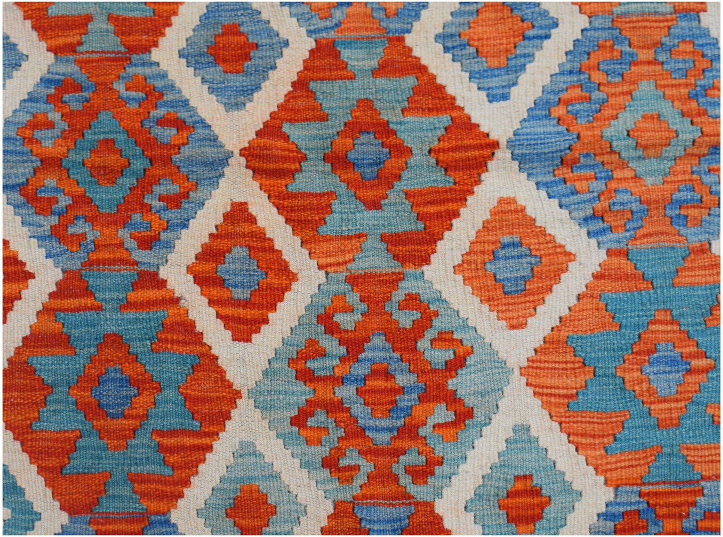 Handwoven Afghan Maimana kilim featuring a vibrant geometric diamond pattern in orange and blue.