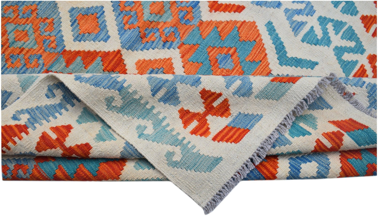 A handmade Afghan Maimana kilim rug featuring a geometric pattern in vibrant orange and blue.