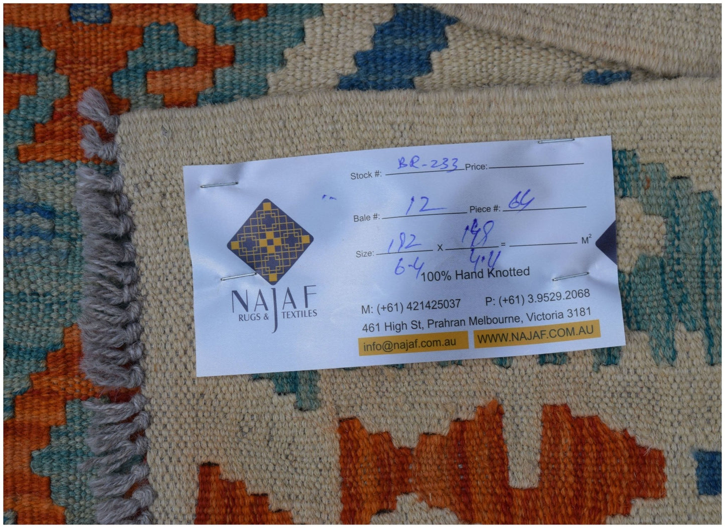 A handwoven Afghan Maimana kilim featuring geometric patterns in orange, blue, and cream tones.