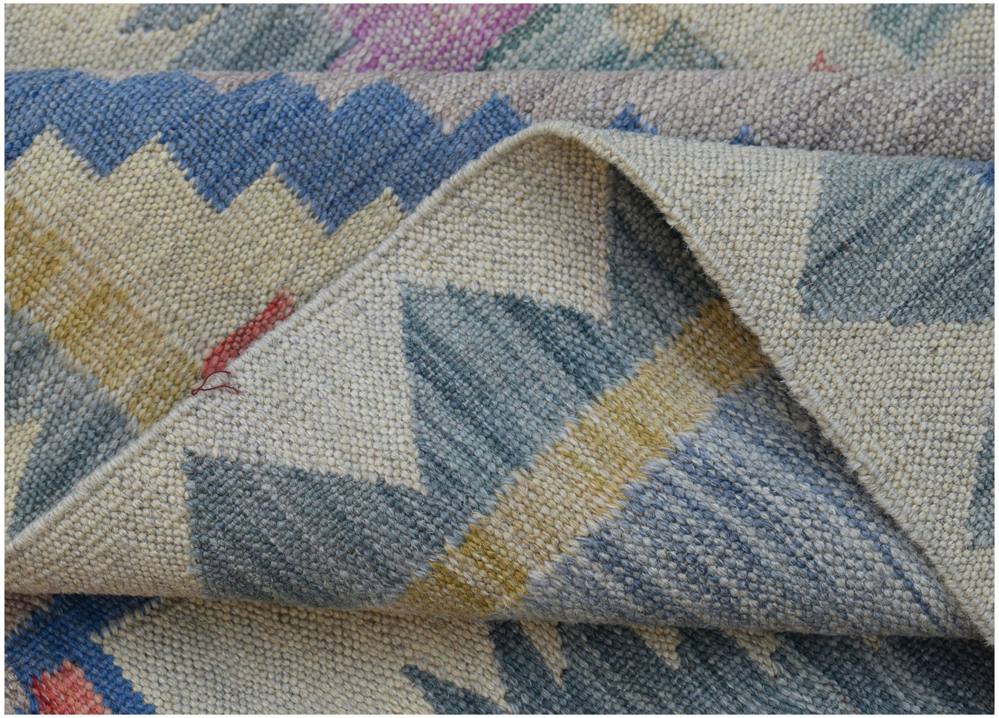 A handwoven Afghan Maimana kilim rug featuring a geometric pattern in blue, yellow, and grey tones.