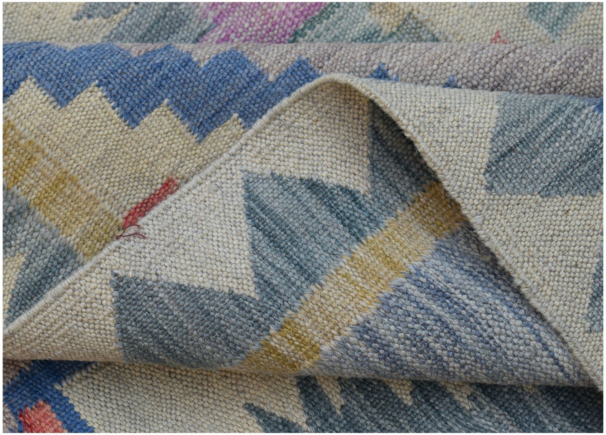 A handwoven Afghan Maimana kilim rug featuring a geometric pattern in blue, yellow, and grey tones.