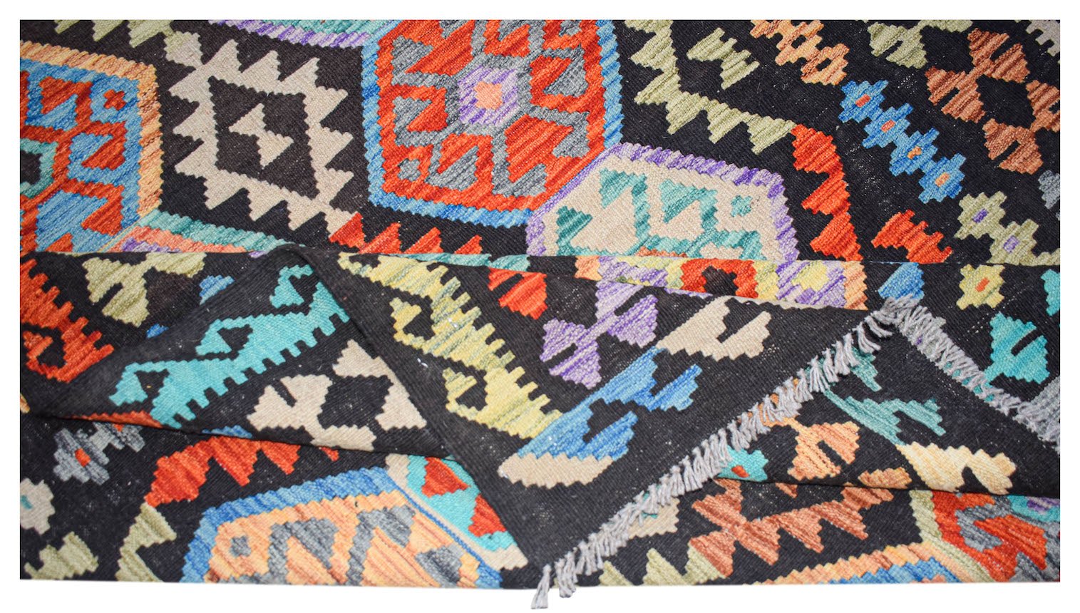 Handwoven Afghan Maimana kilim rug featuring a vibrant geometric pattern on a black background.