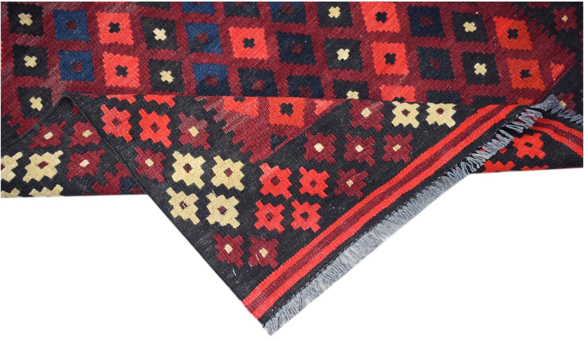 Handwoven Afghan Maimana kilim featuring a geometric pattern in red, blue, and cream wool.