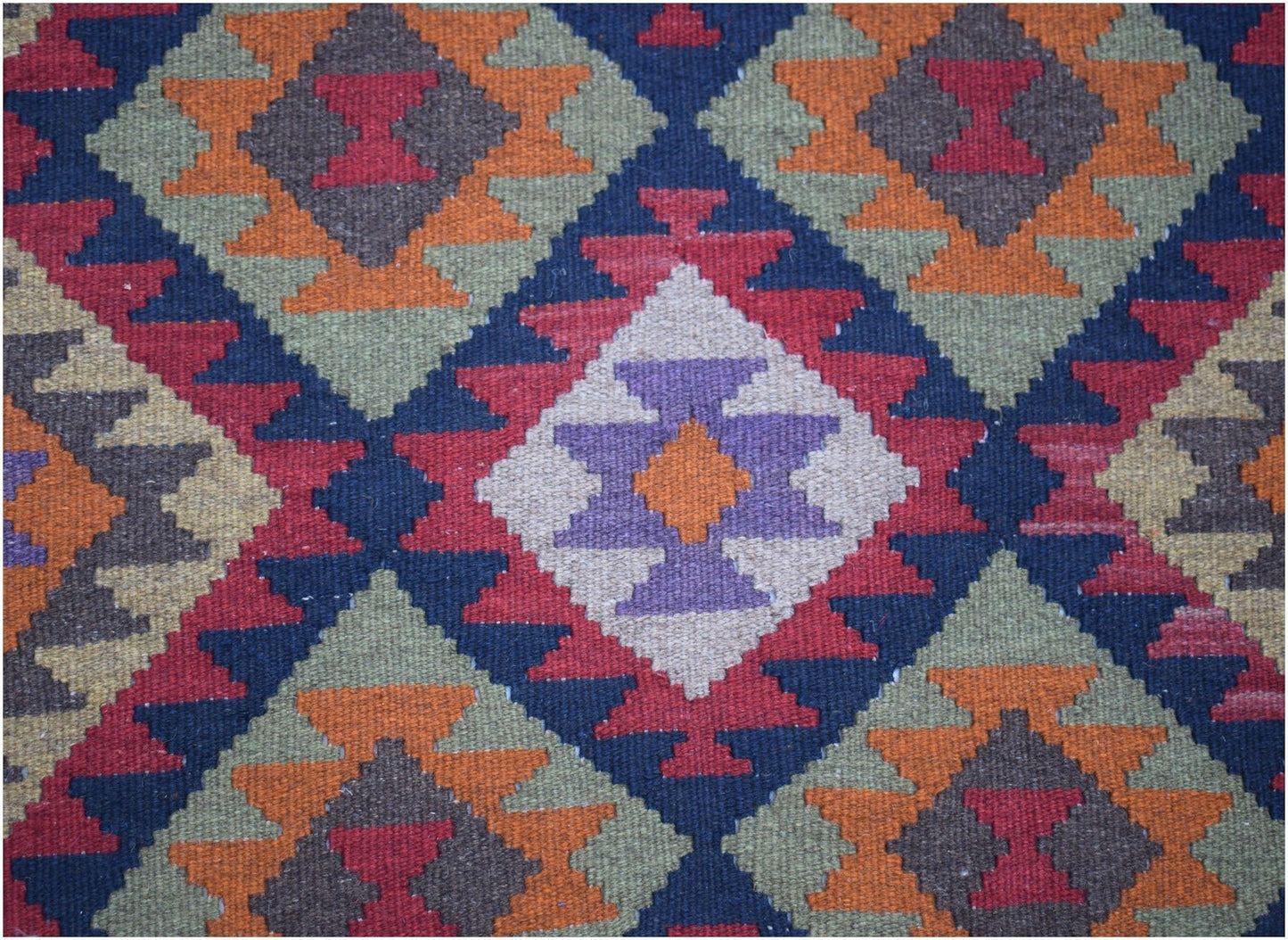 Handwoven Afghan Maimana kilim featuring a geometric diamond pattern in vibrant wool colors.