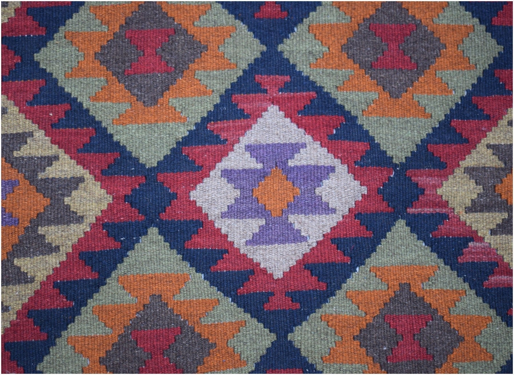 Handwoven Afghan Maimana kilim featuring a geometric diamond pattern in vibrant wool colors.