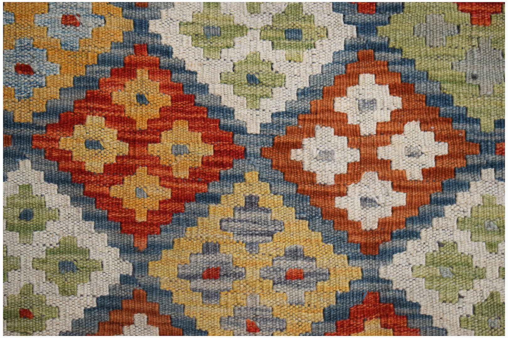 Handwoven Afghan Maimana kilim featuring a geometric diamond pattern in vibrant wool colors.