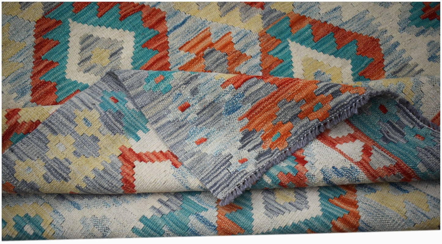 A handmade Afghan Maimana kilim rug featuring a geometric pattern in blue, orange, and yellow.